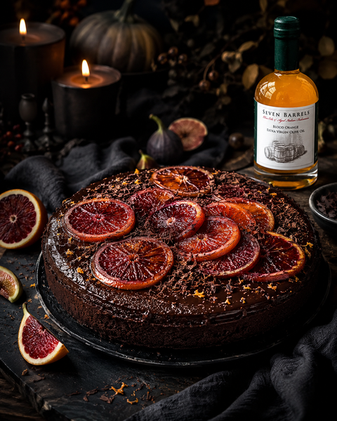 Dark chocolate cake topped with blood orange slices and Seven Barrels Blood Orange Extra Virgin Olive Oil in a moody Halloween setting