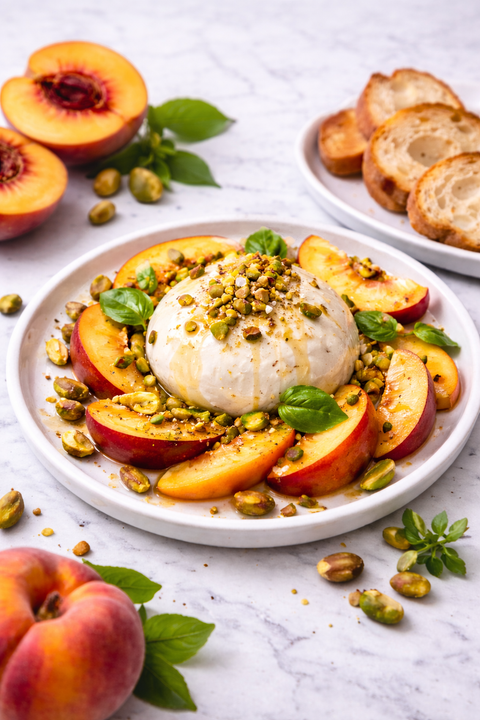 Burrata with fresh peaches, pistachios and basil drizzled with peach balsamic vinegar and olive oil