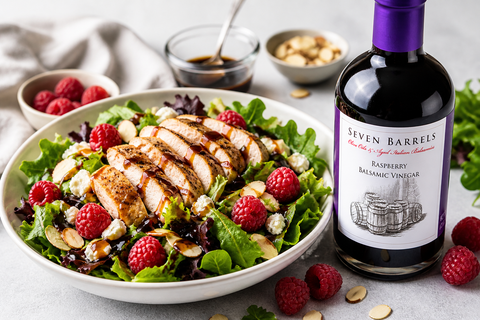 Raspberry balsamic chicken salad with fresh greens, raspberries, and almonds served with Seven Barrels balsamic