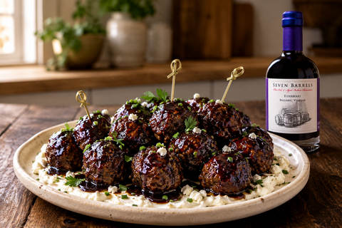 Sticky Elderberry Balsamic glazed meatballs served over whipped goat cheese