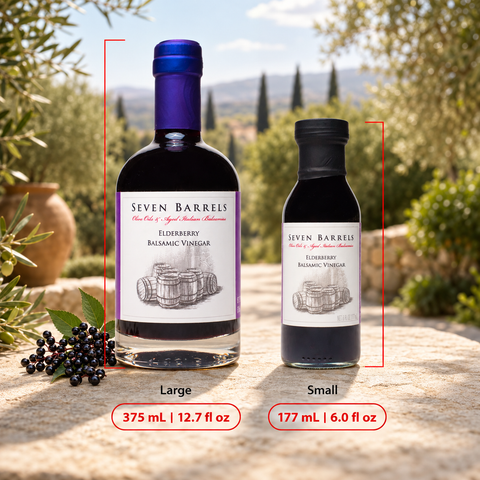 Two bottles of Seven Barrels Elderberry Balsamic Vinegar shown outdoors on a stone surface, with a large bottle labeled Large (375 mL / 12.7 fl oz) and a smaller bottle labeled Small (177 mL / 6.