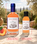 Two bottles of Seven Barrels Peach Balsamic Vinegar shown outdoors on a stone surface, labeled Large (375 mL / 12.7 fl oz) and Small (177 mL / 6.