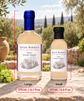 Two bottles of Seven Barrels White Balsamic Vinegar shown on a stone surface outdoors, labeled Large (375 mL / 12.7 fl oz) and Small (177 mL / 6.