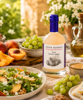 Seven Barrels White Balsamic Vinegar served with fresh peaches, grapes, artisan salad, walnuts, and summer vinaigrette in a Mediterranean-style outdoor setting.